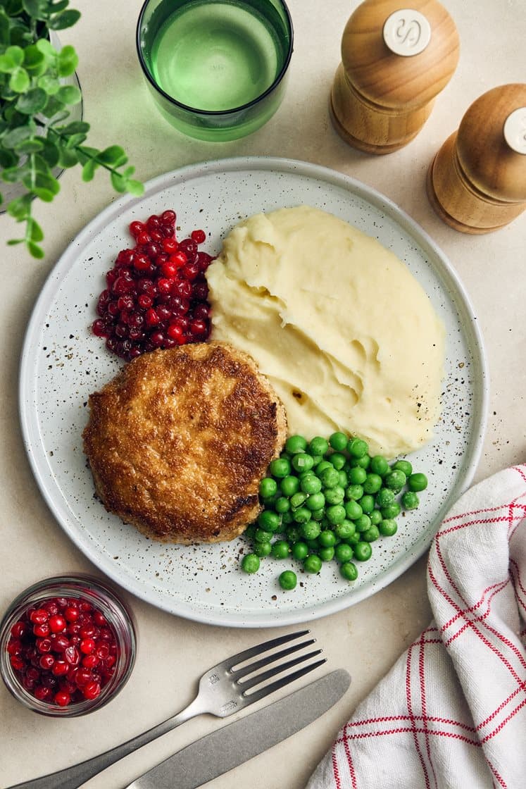 Fläskwallenbergare med potatispuré, gröna ärtor och rårörda lingon