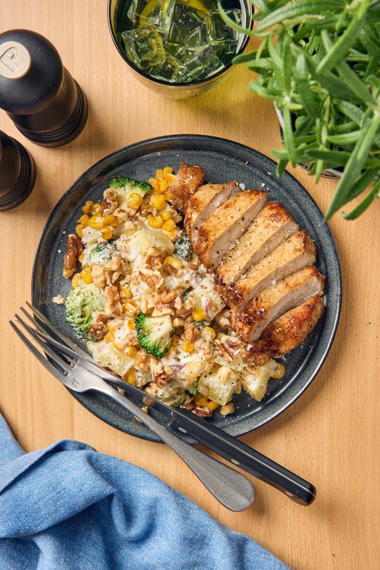 Fläskkotlett och potatissallad med broccoli, majs och valnötter