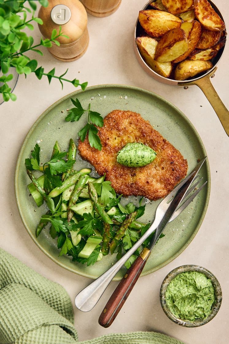 Pankopanerad fläskkotlett med ramslökssmör och ljummen grön sparrissallad