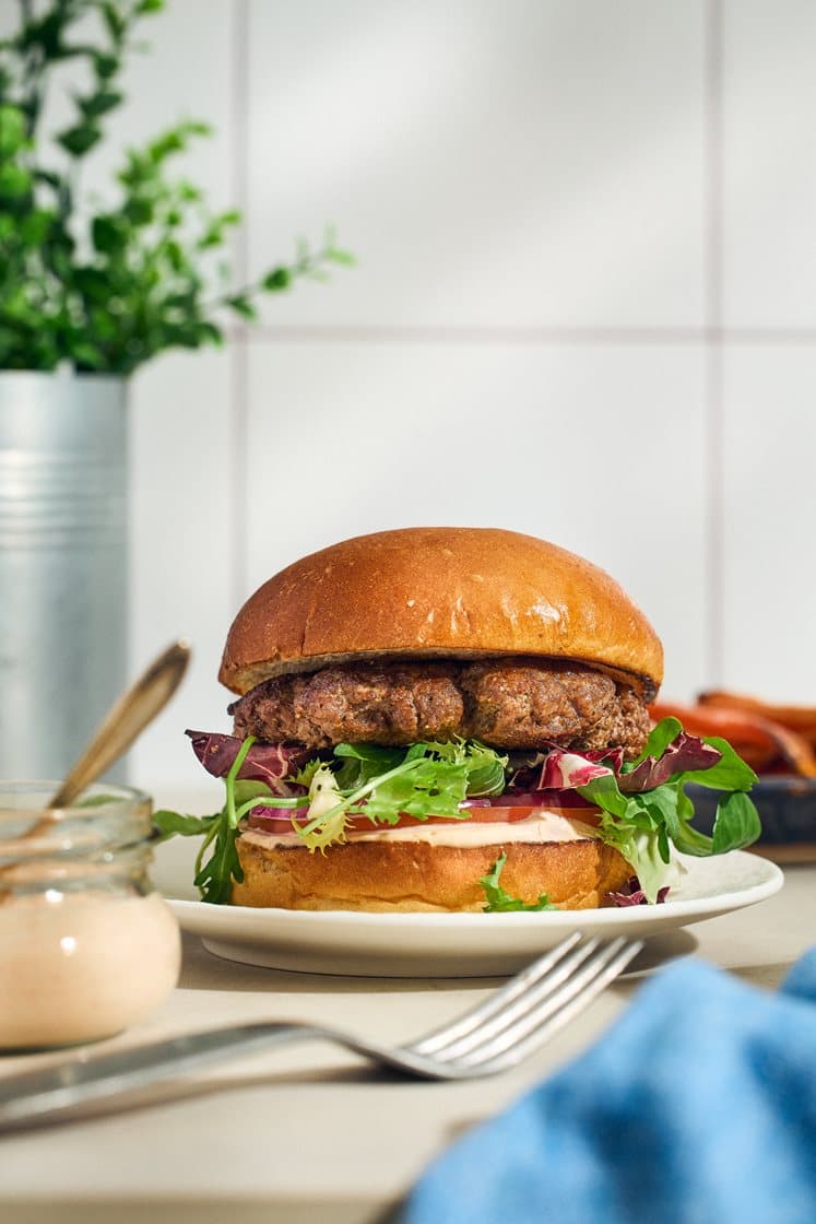 Burgare med het hamburgerdressing och rostade morötter
